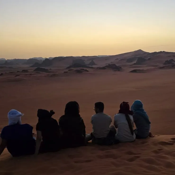 Voyageurs sur une dune au crépuscule