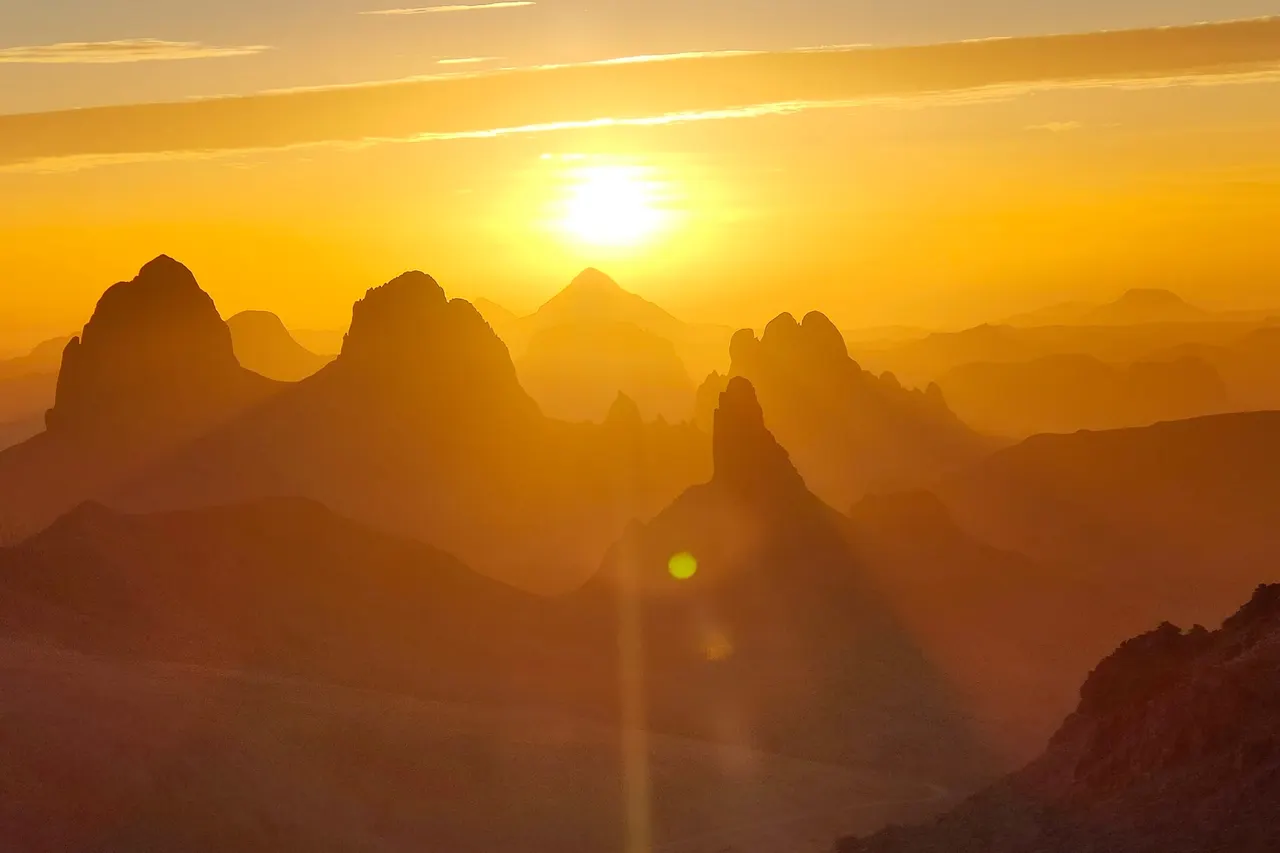 Soleil levant dans la brume dorée, au-dessus des aiguilles de l'Atakor